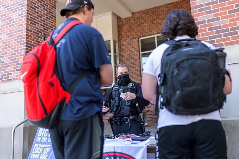 Two students stand in front of Police informational table.