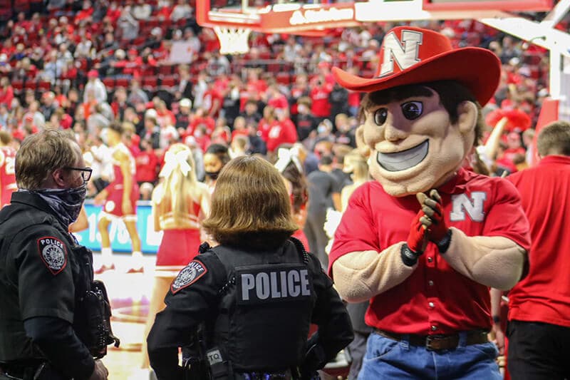 Herbie Husker applauds an officer.