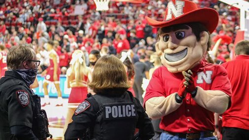 Herbie Husker applauds an officer.