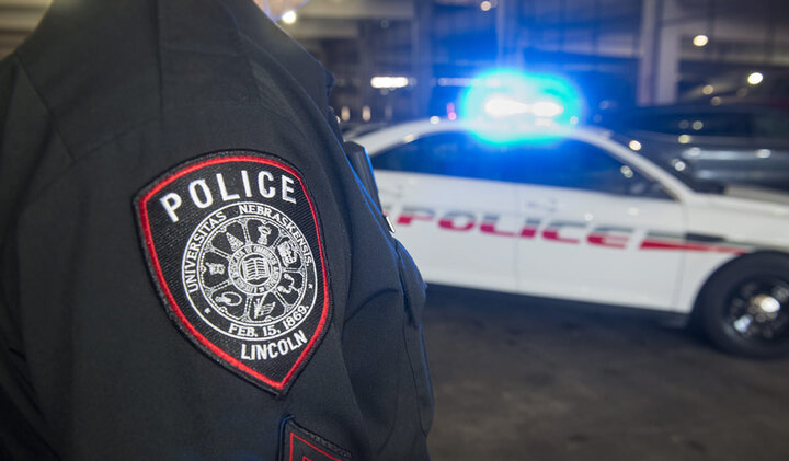 Officer's badge patch with cruiser in the background.