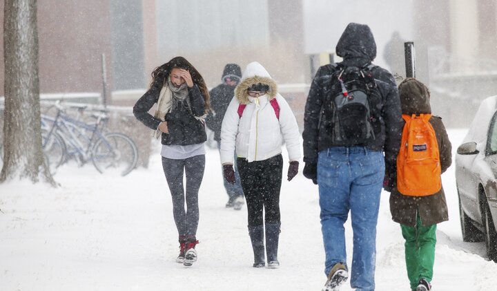 Students walk across campus in the snow.